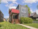 Modern two-story home with gray exterior, red awning, cozy front porch, and manicured lawn at 1430 Fletcher Ave, Indianapolis, IN 46203