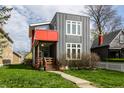 Contemporary two-story home showcasing gray siding, a red balcony, and a welcoming front porch at 1430 Fletcher Ave, Indianapolis, IN 46203