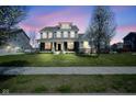 Charming two-story home featuring a well-manicured lawn and beautiful flowering trees at 15594 Garrano Ln, Fishers, IN 46040