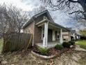 Side view of a home with a charming porch and wooden fence in a quiet neighborhood at 1626 S State Ave, Indianapolis, IN 46203