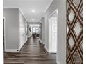 Inviting hallway featuring wood-look flooring, neutral gray walls, white trim and decorative mirror at 19414 Mcbee Ave, Westfield, IN 46074