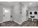 Functional mudroom with wood-look flooring, white trim, convenient bench and coat hooks, and exterior doors at 19414 Mcbee Ave, Westfield, IN 46074
