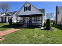 Charming exterior of a two-story home with front porch, landscaped yard, and brick walkway at 2029 Winton Ave, Indianapolis, IN 46224