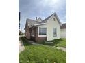 Exterior view of a home showing the siding, windows, and compact yard with scattered dandelions at 2157 S Meridian St, Indianapolis, IN 46225