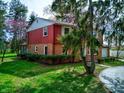 A beautiful two-story red brick home complemented by lush green lawn and mature trees at 2215 W State Rd, Pendleton, IN 46064