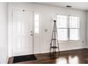 Bright entryway featuring a white front door, wood floors, and a large window at 2615 N Delaware St, Indianapolis, IN 46205