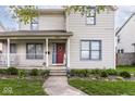 Inviting two-story home featuring a cozy front porch with decorative plants and walkway at 2615 N Delaware St, Indianapolis, IN 46205