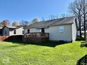 Spacious backyard featuring a well-maintained lawn and a wooden deck perfect for entertaining at 305 S Schroeder Rd, Muncie, IN 47304