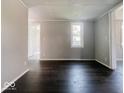 Neutral-colored living room featuring hardwood floors and freshly painted walls at 312 S Gharkey St, Muncie, IN 47305