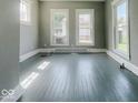 Bright living space with large windows and painted hardwood flooring at 312 S Gharkey St, Muncie, IN 47305