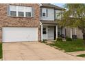 Inviting two-story home with a well-manicured lawn, a two-car garage, and a cozy front porch with accent chairs at 350 Springfield Cir, Greenwood, IN 46143