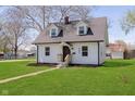 Well-maintained two-story home with a pathway, green lawn, light siding, and mature trees in a suburban setting at 402 N 19Th Ave, Beech Grove, IN 46107