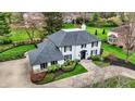 Aerial view of an elegant home featuring a beautiful landscape, dark roof, and winding driveway at 4339 Royal Pine Blvd, Indianapolis, IN 46250
