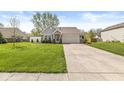 Single-story home featuring a brick and siding facade, well-maintained lawn, and an attached two-car garage at 47 Thornburg Pkwy, Brownsburg, IN 46112