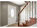 Interior view of the foyer featuring the front door and the wooden staircase at 4786 N Mill Ct, Greenfield, IN 46140
