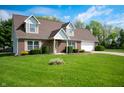 Lovely brick house with green lawn, blue skies, and a two-car garage on a sunny day at 4786 N Mill Ct, Greenfield, IN 46140