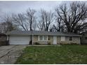 A single story home with a two car garage, gray shingled roof, and patchy front lawn at 5858 E 44Th St, Indianapolis, IN 46226