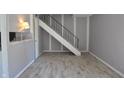 Spacious living area with wood-look flooring and staircase with black railings at 6512 Lupine Ter # 6512, Indianapolis, IN 46224