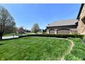 Charming home featuring a well-kept green lawn, flowering trees, and an attached garage at 7128 Trail Ridge Ln, Indianapolis, IN 46259
