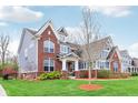 Lovely traditional home with brick and siding exterior, complemented by a lush green lawn and attractive landscaping at 7501 Independence Dr, Zionsville, IN 46077