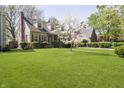 Beautiful brick house featuring a lush green lawn and mature trees at 908 N Bolton Ave, Indianapolis, IN 46219