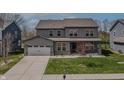 Inviting two-story home with gray siding, green lawn, and a convenient two-car garage at 9800 Ridgecrest Ln, McCordsville, IN 46055