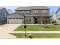 Charming two-story home with gray siding, a well-manicured lawn, and a concrete driveway at 9800 Ridgecrest Ln, McCordsville, IN 46055