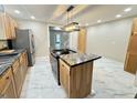 Open kitchen layout with a central island, granite countertop, and stylish lighting at 1001 N 14Th St, Elwood, IN 46036