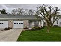Inviting single-story home featuring brick accents, a well-kept lawn, and covered front porch at 1008 E Apple Lake Dr, Greenfield, IN 46140