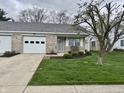 Inviting single-story home featuring brick accents, a well-kept lawn, and covered front porch at 1008 E Apple Lake Dr, Greenfield, IN 46140