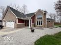 Attractive front exterior with a two-car garage, brick and vinyl siding, and manicured landscaping at 1066 N Dogwood Way, Greenfield, IN 46140
