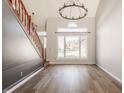 Bright living room featuring hardwood floors, large windows, and decorative chandelier at 10775 Northhampton Dr, Fishers, IN 46038