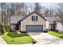 Attractive home with a gray two-car garage, a brick facade, and green landscaping at 10839 Cedar Pine Dr, Indianapolis, IN 46235
