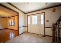 Inviting home foyer with tile flooring, decorative front door, and staircase at 130 Governors Ln, Zionsville, IN 46077