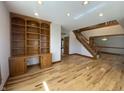 Living room with wood floors, built-in shelving, and an open layout leading to the staircase at 1394 Cherry Tree Rd, Avon, IN 46123