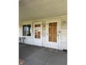 Inviting covered front porch with traditional doors, windows, and a small table for outdoor enjoyment at 1625 E Thompson Rd, Indianapolis, IN 46227