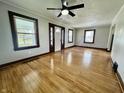 Spacious living room with gleaming hardwood floors, large windows, and neutral paint at 1942 E Edgewood Ave, Indianapolis, IN 46227