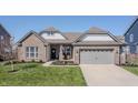 Charming home with brick and siding, a well-manicured lawn, a 2-car garage, and great curb appeal at 20515 Quicksilver Rd, Noblesville, IN 46062