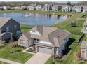Beautiful home with water view, brick and siding, a well-manicured lawn, and a 2-car garage at 20515 Quicksilver Rd, Noblesville, IN 46062