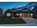 Charming home with brick and siding, a well-manicured lawn, a 2-car garage, and warm exterior lighting at 20515 Quicksilver Rd, Noblesville, IN 46062