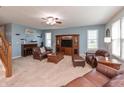 Inviting living room with comfortable leather seating, a cozy fireplace, and plenty of natural light from large windows at 2093 Autumn Faith Way, Avon, IN 46123