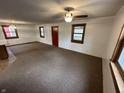Spacious living room featuring neutral carpeting, a ceiling fan, and natural light from multiple windows at 2975 High Rock Dr, Martinsville, IN 46151