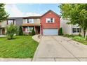 Charming two-story home with a brick facade, attached garage, and manicured lawn at 3316 Gainesville Ct, Indianapolis, IN 46227