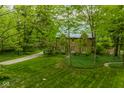 Charming brick home with lush green lawn and mature trees offers a serene and private setting at 4151 N Pennsylvania St, Indianapolis, IN 46205