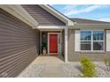 Inviting entryway featuring a bright red door and stylish landscaping at 4323 Stubbington Ln, Indianapolis, IN 46239