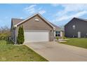 Well-maintained home featuring an attached two-car garage and manicured lawn at 4323 Stubbington Ln, Indianapolis, IN 46239