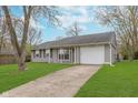 Single-story home with an attached garage and a concrete driveway at 4326 Burrwood Dr, Indianapolis, IN 46235