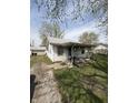 Quaint home with a cozy porch, a well-kept lawn, and a detached garage in the background at 434 N 18Th Ave, Beech Grove, IN 46107