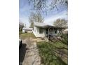 Cozy home features a quaint front porch, neat yard, detached garage, and gravel driveway at 434 N 18Th Ave, Beech Grove, IN 46107