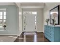 Bright foyer featuring hardwood floors, a decorative dresser, and a front door with sidelights at 4546 Creighton Ln, Indianapolis, IN 46237